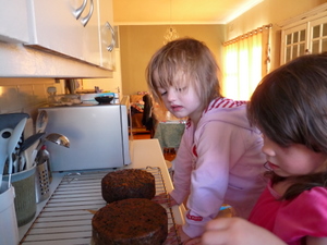 Girls take paper off christmas cakes